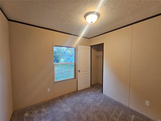 unfurnished bedroom featuring a textured ceiling, a closet, and carpet flooring