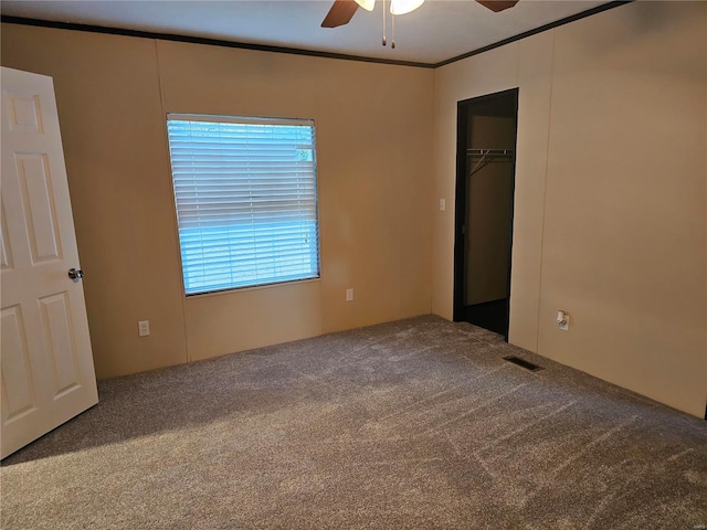 unfurnished bedroom featuring a closet, ceiling fan, carpet, and ornamental molding