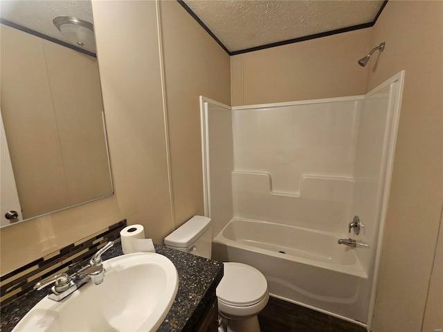 full bathroom featuring vanity, washtub / shower combination, a textured ceiling, and toilet