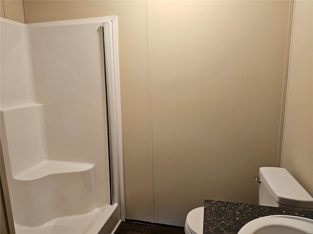 bathroom with vanity, toilet, a shower, and wood-type flooring