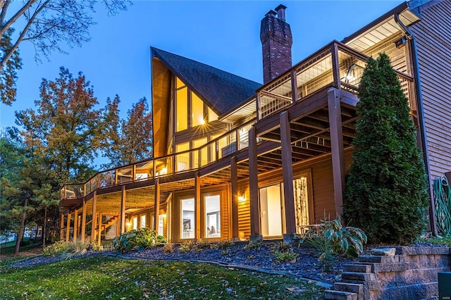 back house at dusk featuring a yard