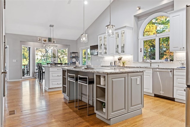 kitchen featuring stainless steel dishwasher, white cabinets, and a kitchen island