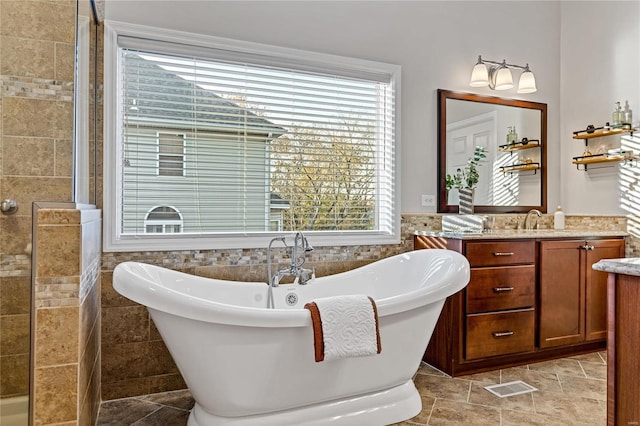 bathroom with tile walls, vanity, and shower with separate bathtub