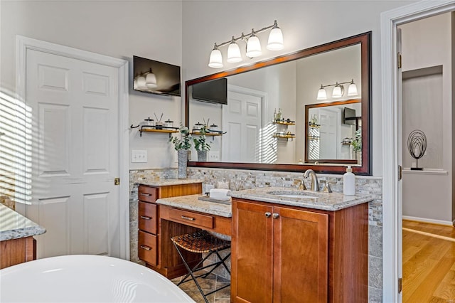 bathroom with vanity, hardwood / wood-style floors, and a bathing tub