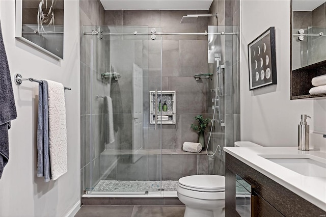 bathroom featuring vanity, an enclosed shower, and toilet