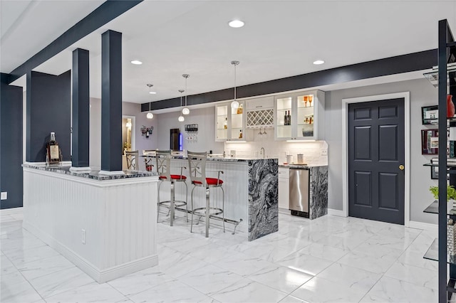 kitchen with a breakfast bar, white cabinetry, hanging light fixtures, backsplash, and stainless steel dishwasher