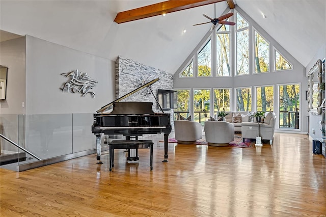 living area featuring hardwood / wood-style flooring, ceiling fan, beam ceiling, and high vaulted ceiling