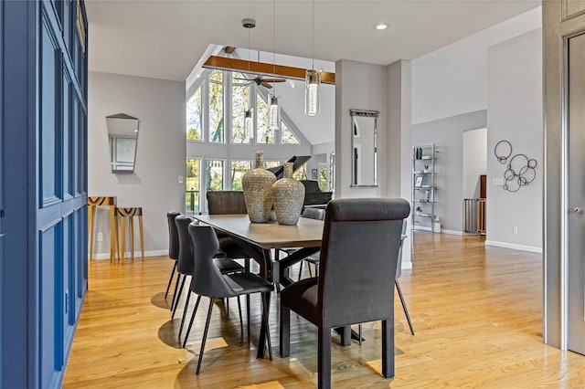 dining area with light hardwood / wood-style flooring, high vaulted ceiling, and ceiling fan