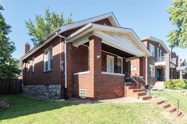 view of front of house featuring a balcony and a front yard