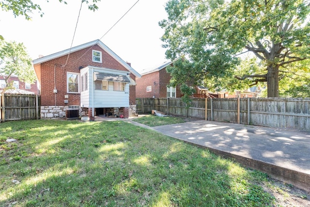 view of yard with central air condition unit and a patio area