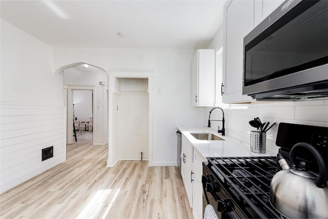 kitchen featuring sink, white cabinets, stainless steel appliances, and light wood-type flooring