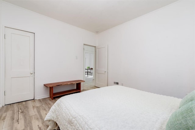 bedroom featuring light hardwood / wood-style floors and ornamental molding