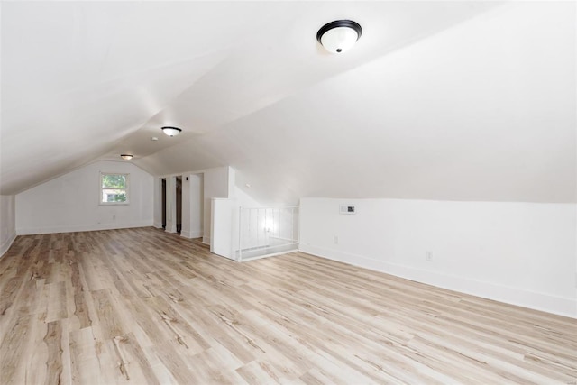 bonus room with lofted ceiling and light wood-type flooring