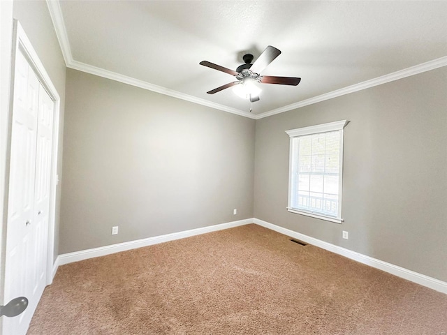 carpeted empty room featuring crown molding and ceiling fan