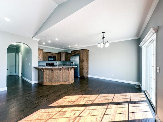 kitchen with ornamental molding, dark hardwood / wood-style flooring, a kitchen bar, and stainless steel fridge