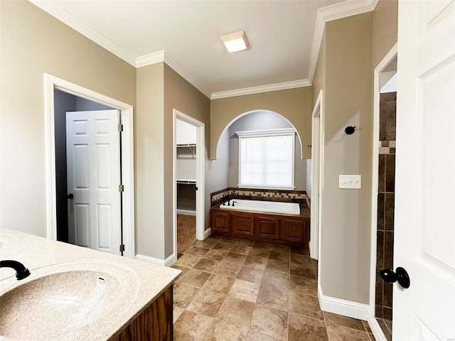 bathroom with ornamental molding, a tub, and vanity