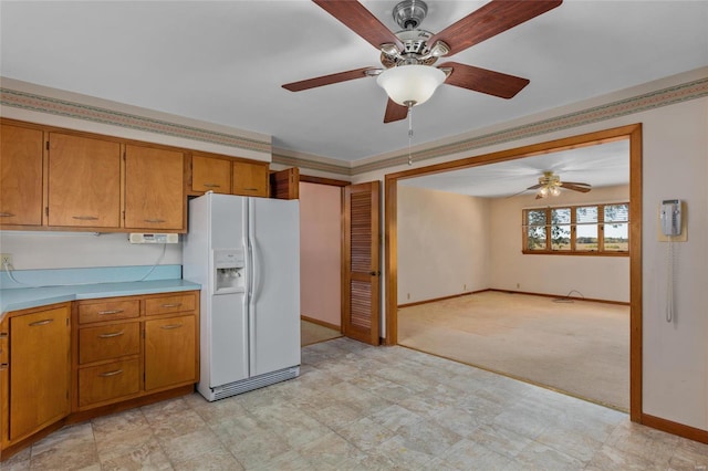 kitchen with white refrigerator with ice dispenser, light colored carpet, and ceiling fan