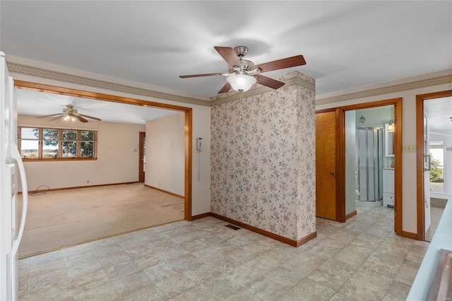 carpeted spare room with ceiling fan, a healthy amount of sunlight, and crown molding