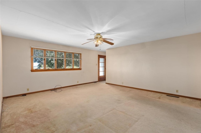 empty room featuring light carpet, plenty of natural light, and ceiling fan