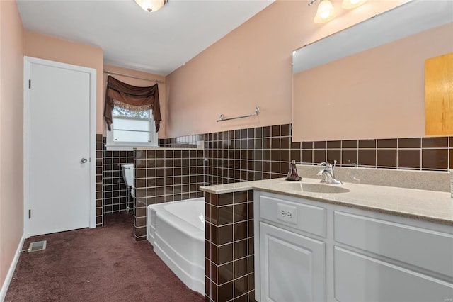 bathroom featuring tile walls, vanity, and a bath