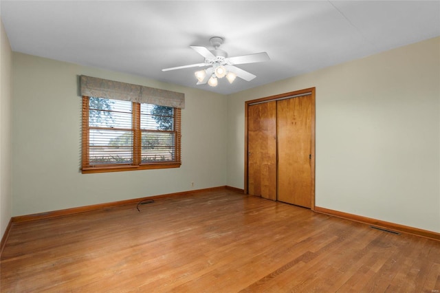 unfurnished bedroom with light hardwood / wood-style flooring, a closet, and ceiling fan