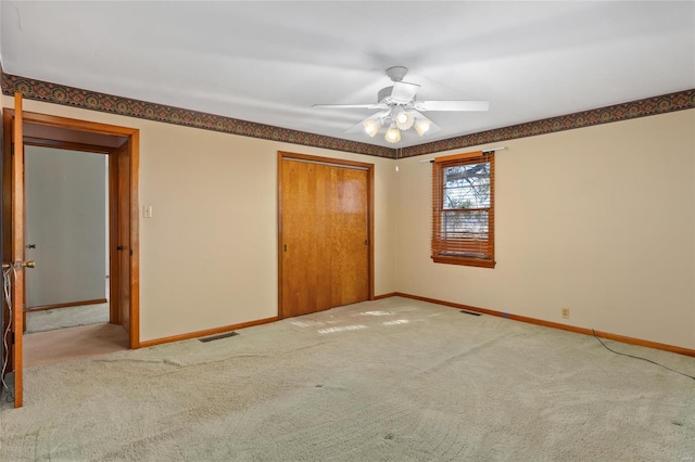 unfurnished bedroom featuring a closet, ceiling fan, and light carpet