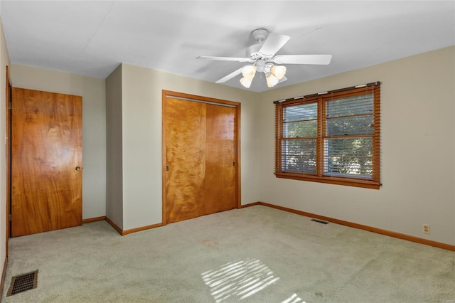 unfurnished bedroom with light colored carpet, a closet, and ceiling fan