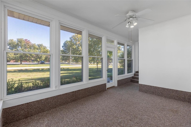 unfurnished sunroom featuring ceiling fan