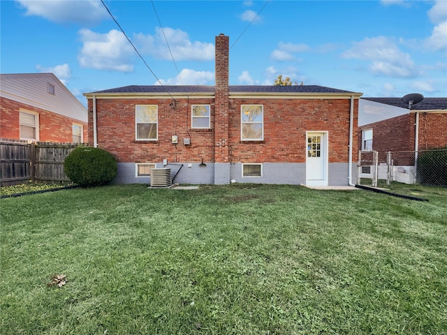 back of house with central AC unit and a lawn