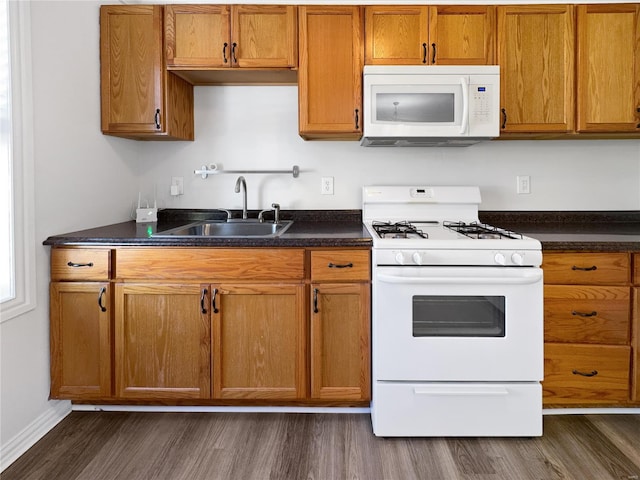 kitchen featuring sink, dark hardwood / wood-style floors, and white appliances