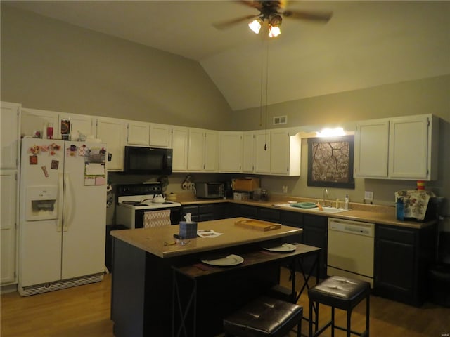 kitchen with white cabinets, a kitchen island, wood-type flooring, sink, and white appliances