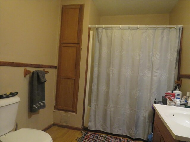 bathroom with toilet, curtained shower, hardwood / wood-style flooring, and vanity