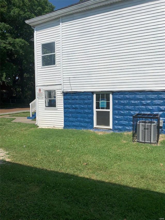 view of property exterior with cooling unit and a yard