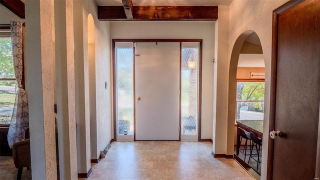 foyer entrance with beamed ceiling