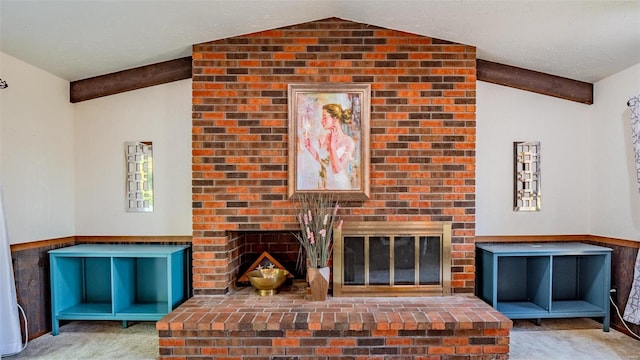 unfurnished living room with vaulted ceiling with beams, carpet floors, a textured ceiling, and a fireplace