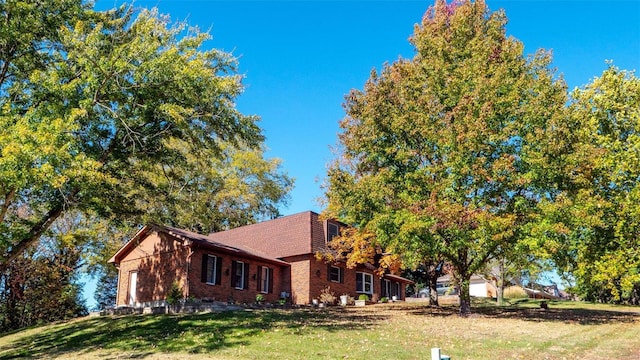 view of front of house with a garage, a front yard, and brick siding