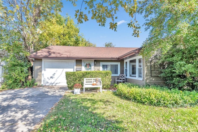 ranch-style house featuring a garage and a front lawn