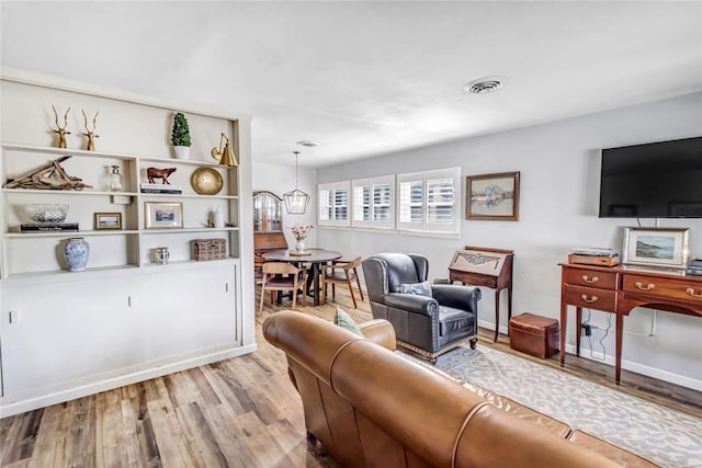 living room featuring light hardwood / wood-style floors and a chandelier