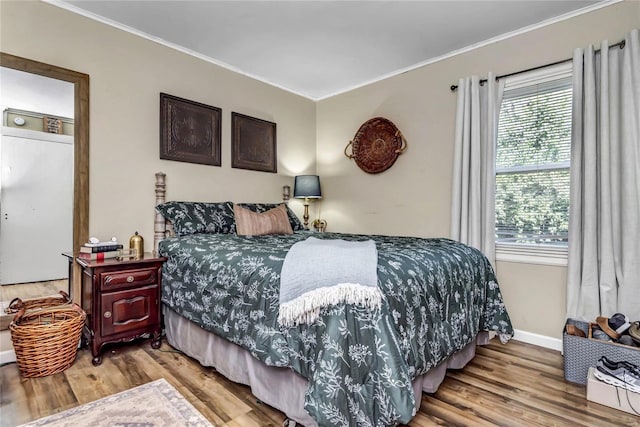 bedroom featuring crown molding and wood-type flooring