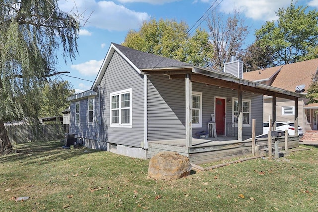 rear view of property featuring a yard, central AC, and a wooden deck