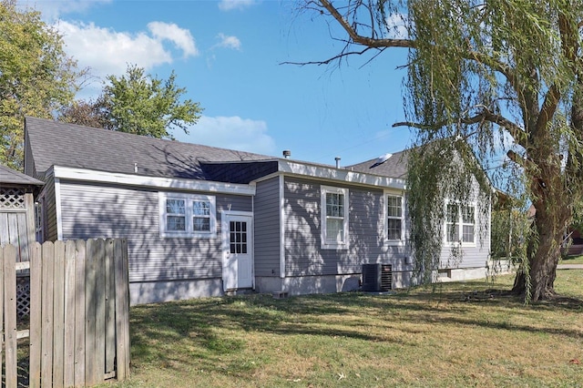 rear view of house featuring a yard and central AC unit