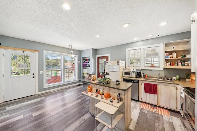 kitchen with sink, appliances with stainless steel finishes, light hardwood / wood-style flooring, and a textured ceiling