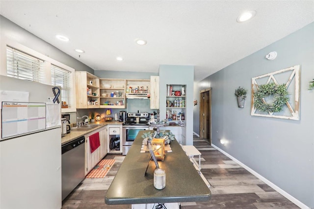 kitchen featuring stainless steel appliances, wood-type flooring, sink, and ventilation hood