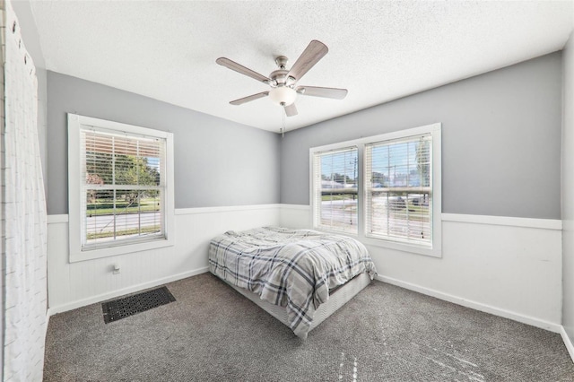 bedroom featuring a textured ceiling, carpet flooring, and ceiling fan