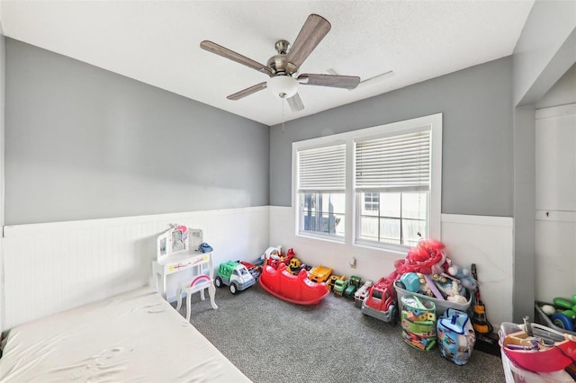 interior space with a textured ceiling, carpet flooring, and ceiling fan