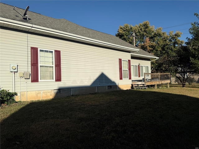 view of side of home featuring a wooden deck and a yard