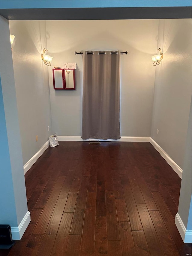 empty room with dark wood-type flooring