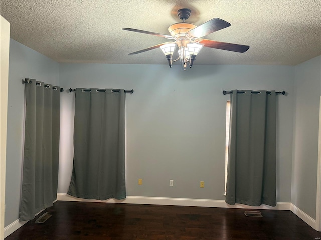 spare room with dark wood-type flooring, ceiling fan, and a textured ceiling