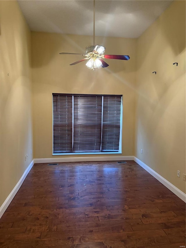 empty room with ceiling fan and dark hardwood / wood-style flooring