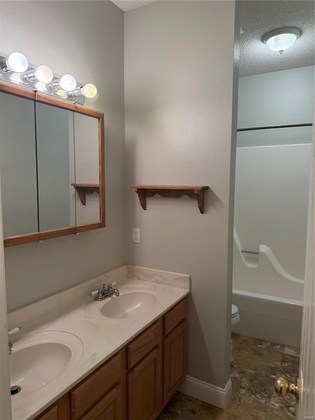 full bathroom featuring vanity, shower / tub combination, a textured ceiling, and toilet